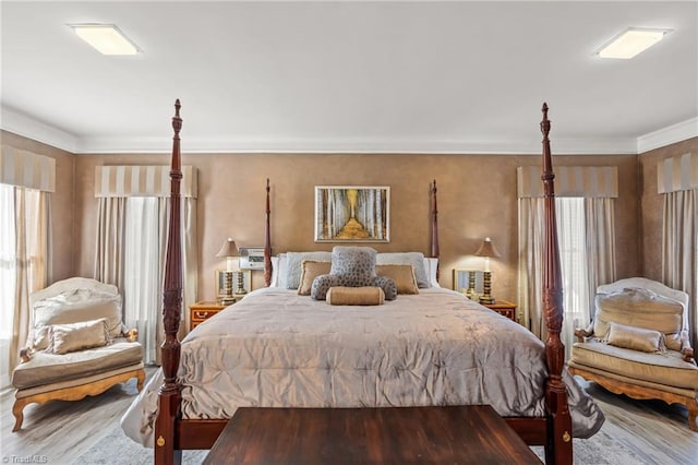 bedroom with wood-type flooring, multiple windows, and crown molding