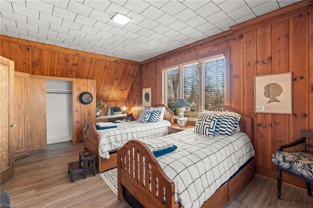 bedroom featuring wood-type flooring, a closet, and ornamental molding