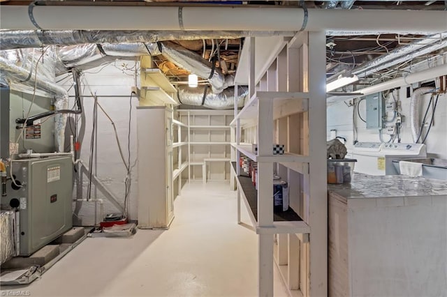 interior space featuring washing machine and clothes dryer, electric panel, and heating unit