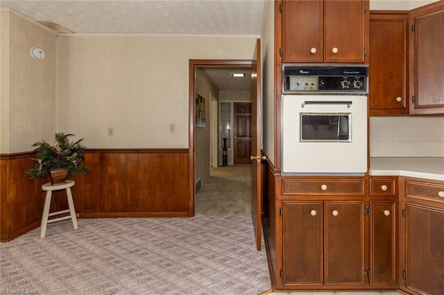 kitchen with oven and light colored carpet