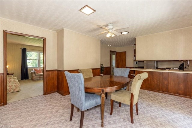 dining space with light carpet and ceiling fan