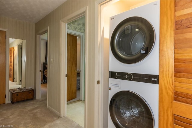 laundry room with stacked washer and clothes dryer and light carpet