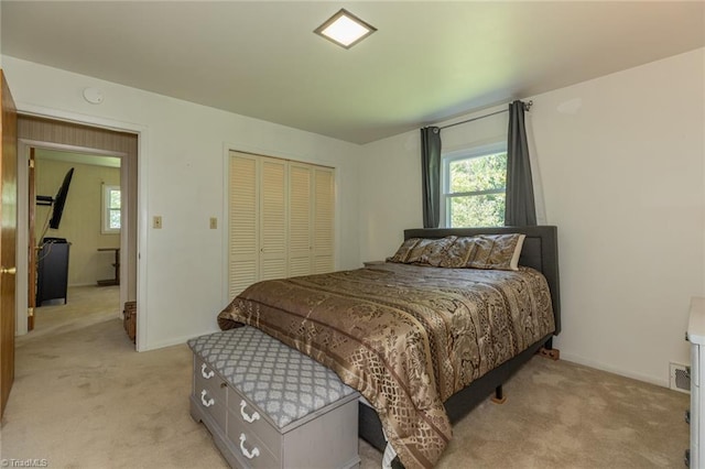 bedroom featuring light colored carpet and a closet