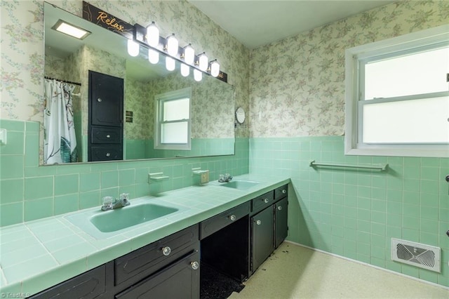 bathroom with tile walls, vanity, and tasteful backsplash