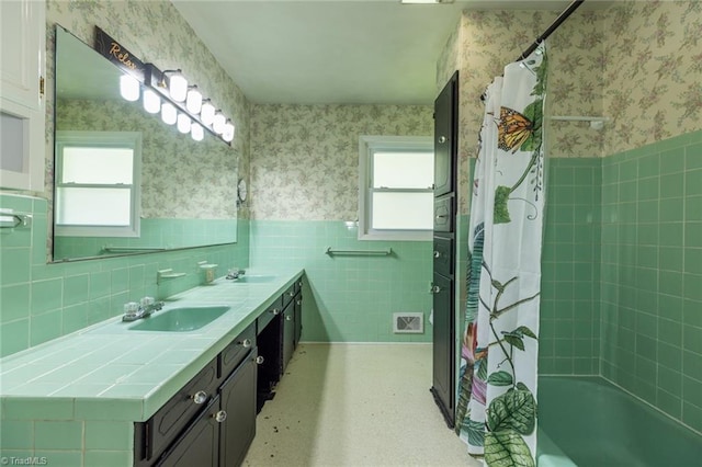 bathroom featuring a healthy amount of sunlight, tile walls, vanity, and decorative backsplash