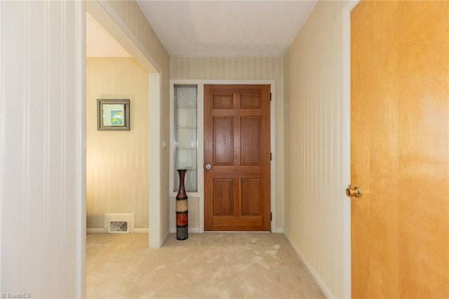 foyer entrance featuring light carpet