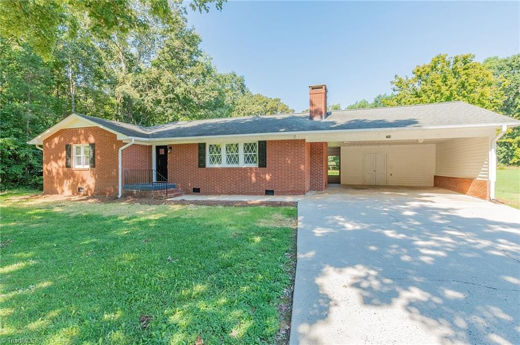 ranch-style house featuring a front yard and a carport