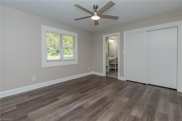 unfurnished bedroom with sink, ensuite bathroom, ceiling fan, a closet, and dark hardwood / wood-style floors