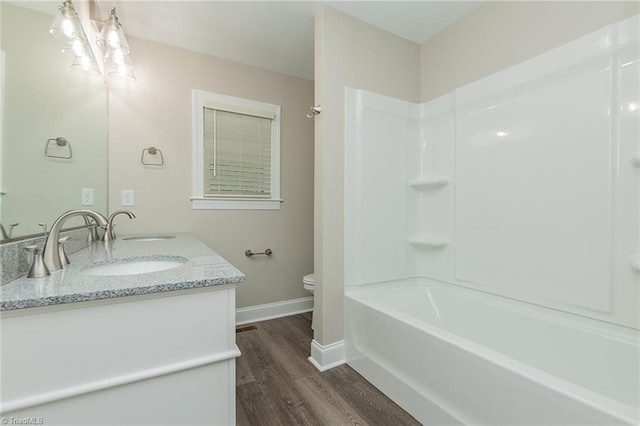 full bathroom with shower / washtub combination, hardwood / wood-style flooring, vanity, and toilet