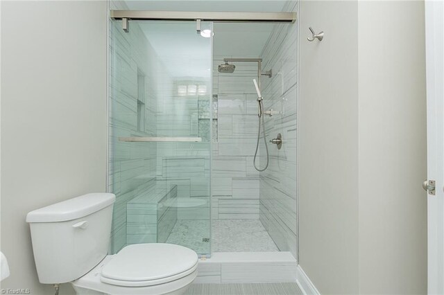 bathroom featuring toilet and an enclosed shower