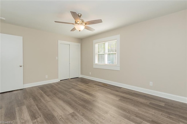 unfurnished bedroom with ceiling fan, hardwood / wood-style floors, and a closet