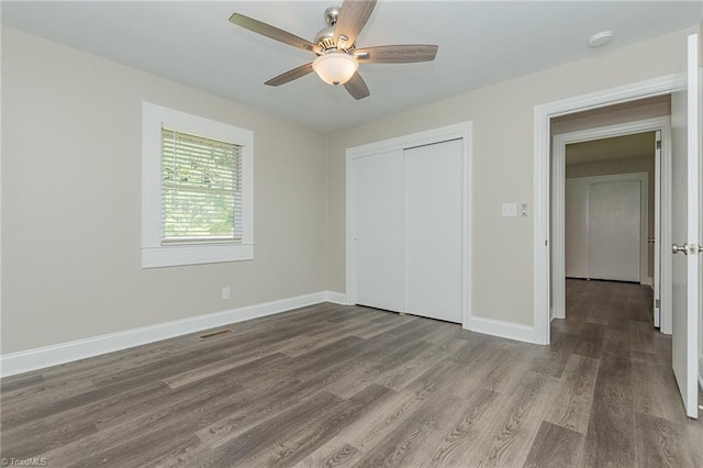 unfurnished bedroom featuring hardwood / wood-style flooring, ceiling fan, and a closet