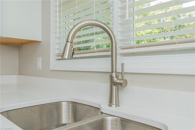 interior details with white cabinetry and sink