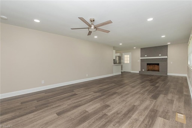 unfurnished living room with wood-type flooring, a fireplace, and ceiling fan