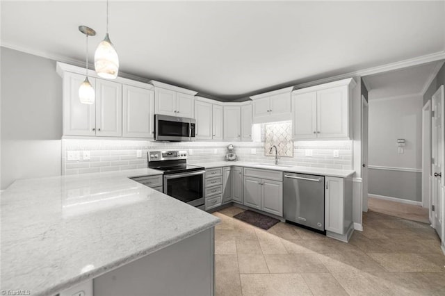 kitchen with stainless steel appliances, a sink, backsplash, hanging light fixtures, and white cabinets