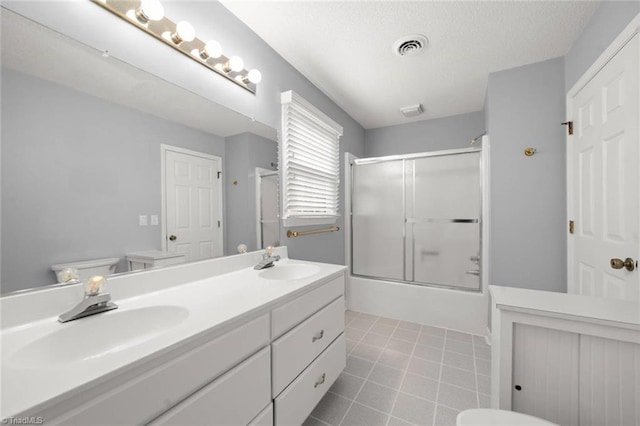 full bath with double vanity, bath / shower combo with glass door, and tile patterned flooring