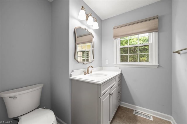bathroom with toilet, vanity, and baseboards