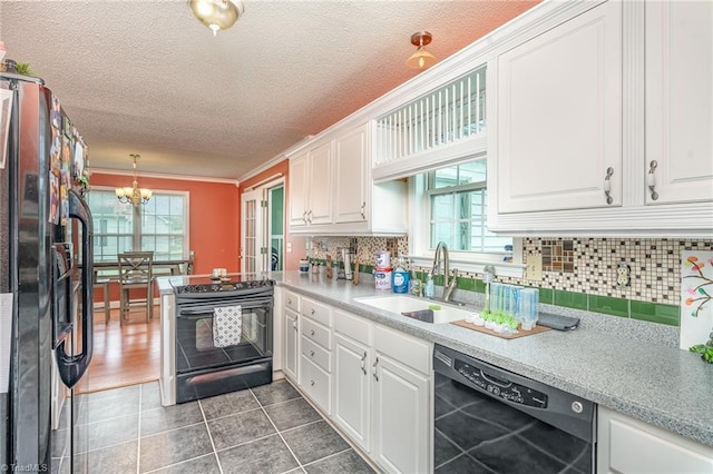 kitchen featuring pendant lighting, white cabinets, sink, and black appliances