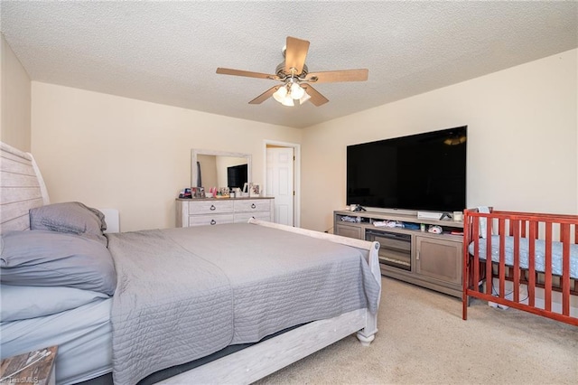 carpeted bedroom with ceiling fan and a textured ceiling