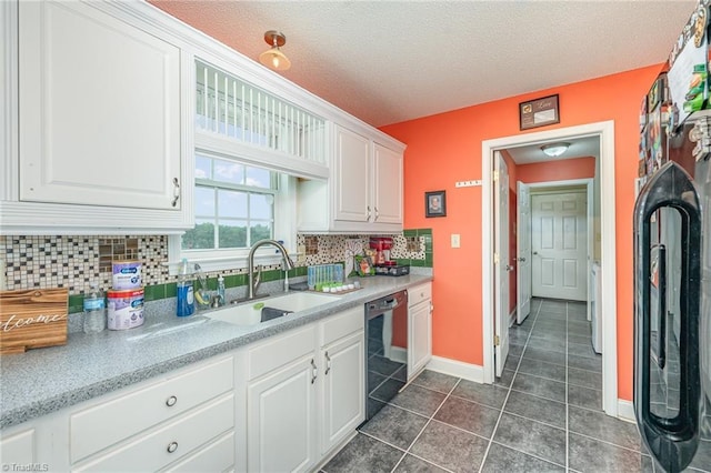 kitchen featuring tasteful backsplash, sink, dark tile patterned flooring, white cabinets, and black appliances