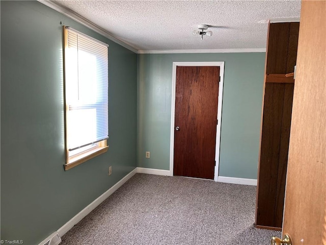 unfurnished room featuring a textured ceiling, carpet floors, and ornamental molding