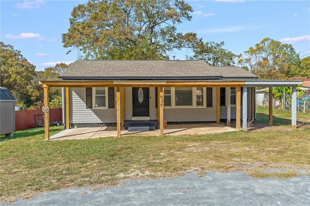 rear view of property featuring covered porch and a yard