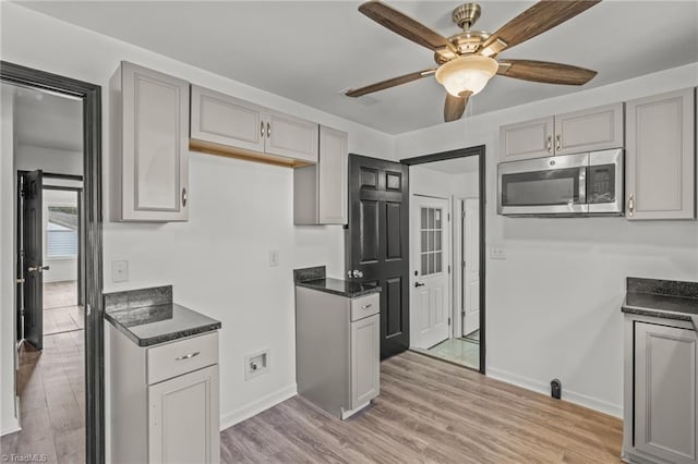 kitchen with gray cabinetry, ceiling fan, and light hardwood / wood-style flooring