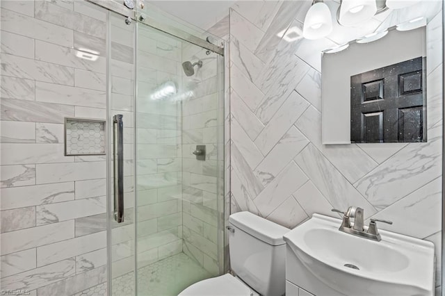 bathroom with a shower with shower door, vanity, toilet, and tile walls