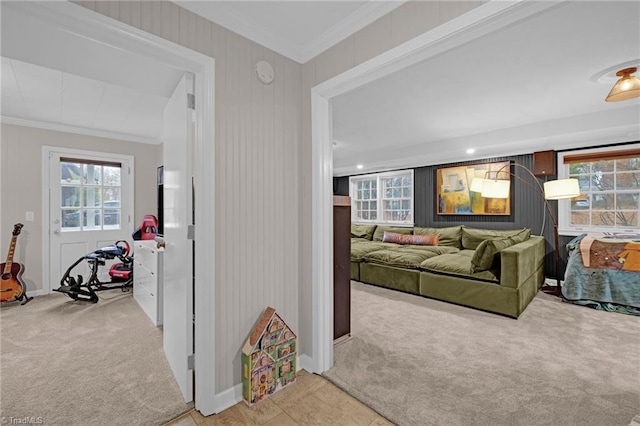 hall with light colored carpet, a healthy amount of sunlight, and ornamental molding