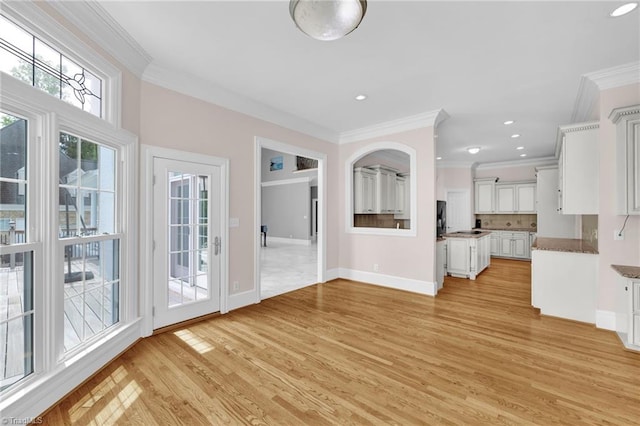 unfurnished living room with crown molding, recessed lighting, baseboards, and light wood finished floors