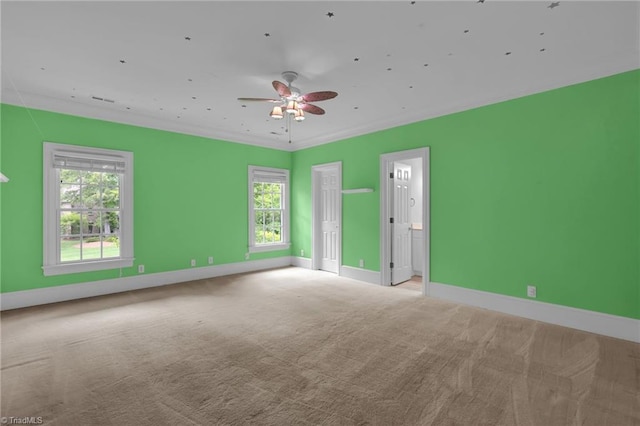 carpeted empty room with baseboards, ceiling fan, and a healthy amount of sunlight