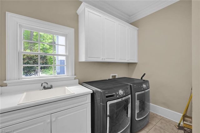clothes washing area featuring cabinet space, a sink, washing machine and dryer, light tile patterned floors, and ornamental molding