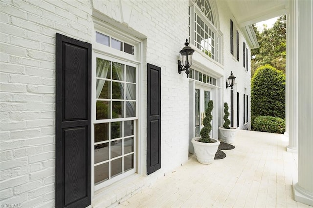property entrance featuring a porch and brick siding