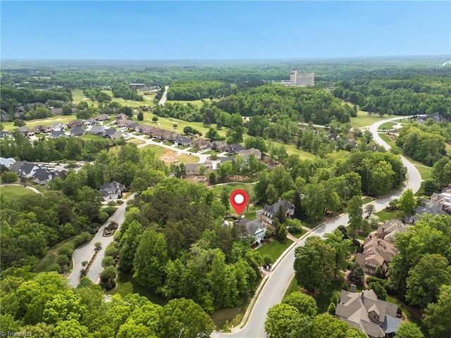 drone / aerial view featuring a view of trees and a residential view