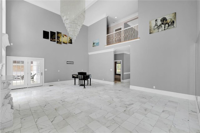 living room featuring marble finish floor, a towering ceiling, baseboards, a chandelier, and french doors