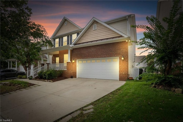 craftsman-style house featuring covered porch, a garage, and a yard