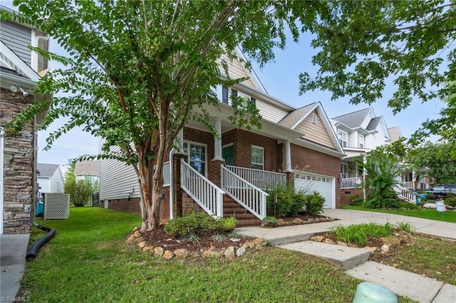 view of front of property with covered porch, a garage, and a front yard