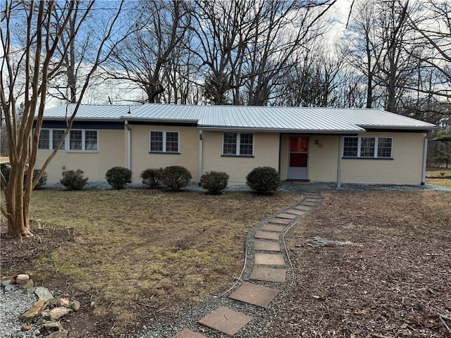 ranch-style home with metal roof and concrete block siding