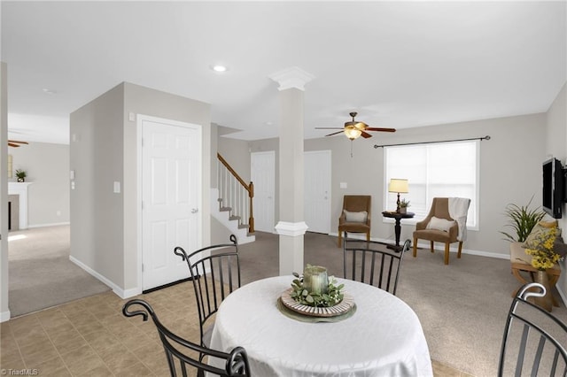 carpeted dining area featuring ceiling fan and decorative columns