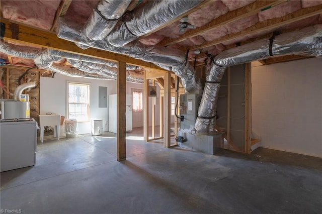 basement featuring white refrigerator, sink, and electric panel