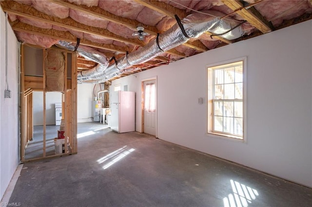 basement featuring white refrigerator and a healthy amount of sunlight