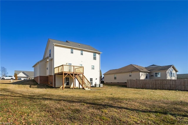 back of property featuring a wooden deck and a yard