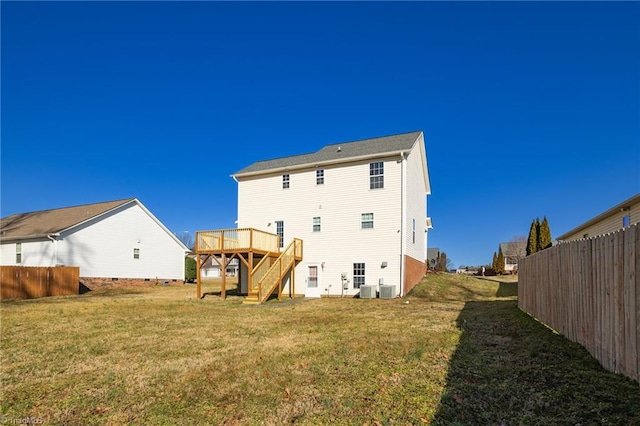 rear view of house featuring a wooden deck, central AC, and a lawn