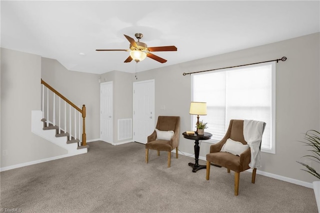 living area with light carpet and ceiling fan