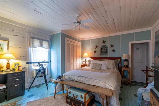 bedroom featuring ceiling fan, wood walls, hardwood / wood-style flooring, a closet, and wooden ceiling