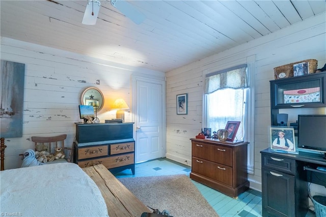 bedroom with ceiling fan, wooden walls, and wood ceiling