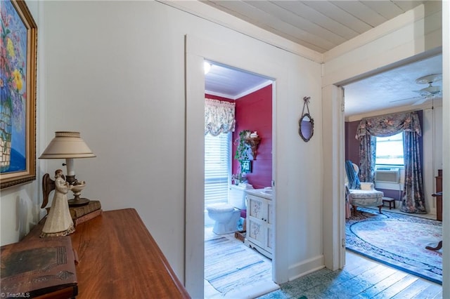 corridor featuring light wood-type flooring and crown molding