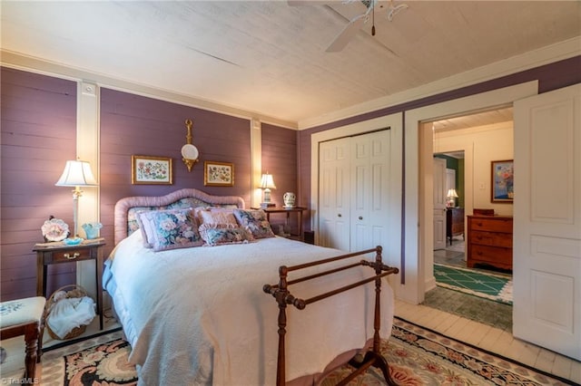 bedroom featuring a closet, wood-type flooring, wood walls, and ceiling fan