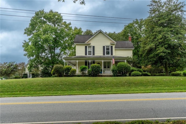 farmhouse-style home with a front lawn and a porch