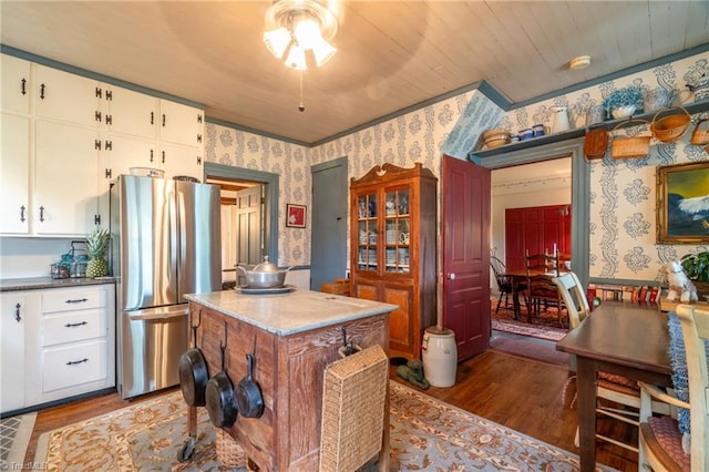 kitchen featuring white cabinets, stainless steel refrigerator, wooden ceiling, a center island, and hardwood / wood-style floors